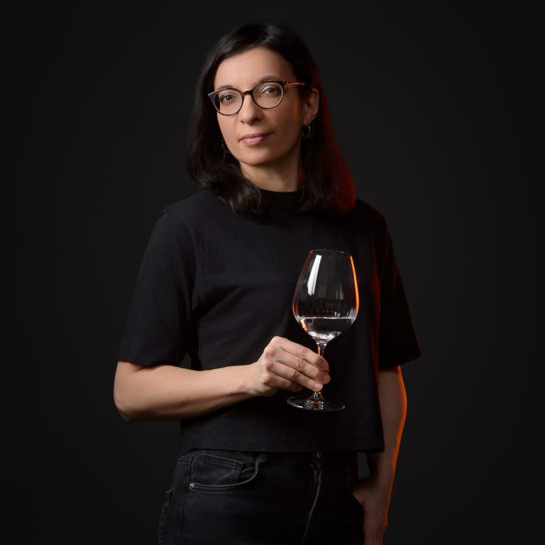 Karen Esteves Ribeiro, sommelière saké, tient un verre de saké à la main.